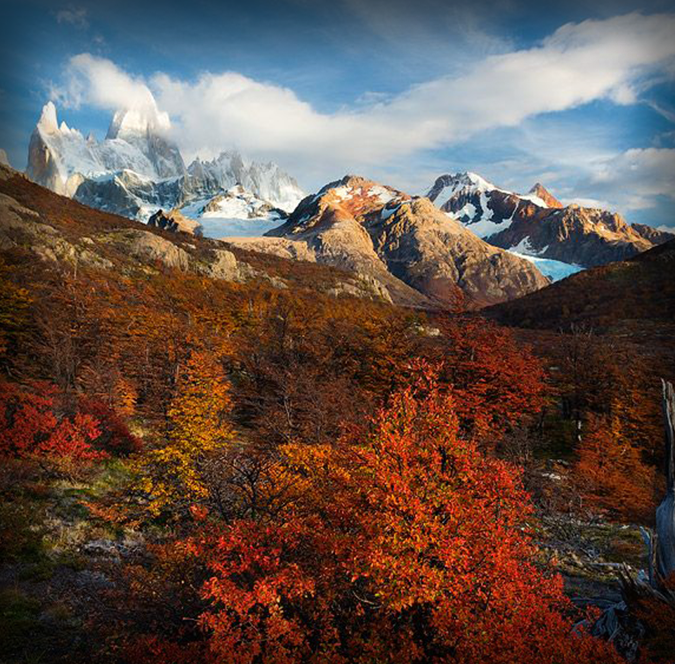 Vibrant autumn foliage and snow-capped mountain peaks during shoulder season travel